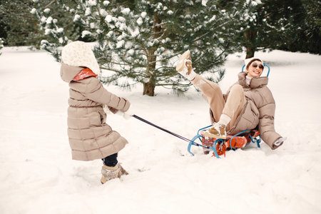 Mother and child in winter clothes play at the yard