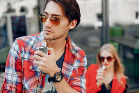Stylish young couple with vape in a cityの写真素材