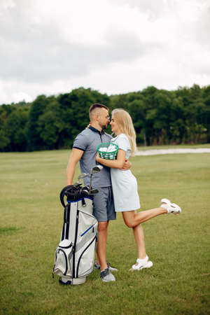 Beautiful couple playing golf on a golf courseの写真素材