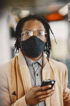 Young African businessman standing in a busの写真素材