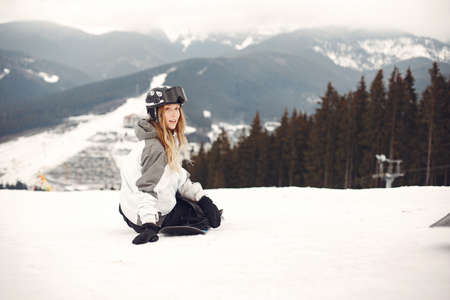 Girl snowboarding in the mountains with the snowboardの写真素材