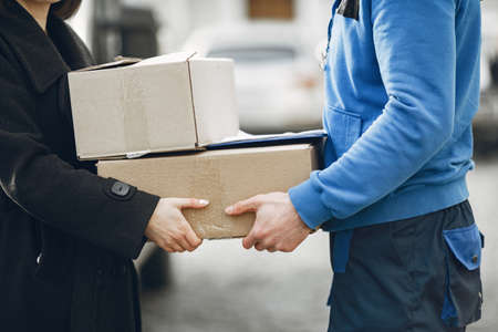 Man gives a parcel to a female clientの写真素材