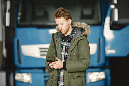 Young man talking on phone near truck