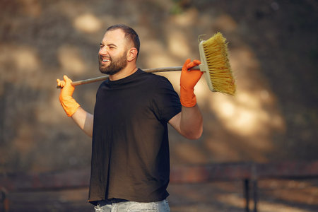 Man collects leaves and cleans the park