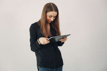 Girl standing on a white background with a laptopの写真素材