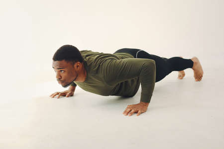 Handsome black man doing yoga on a white backgroundの写真素材