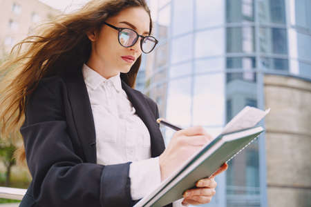 Businesswoman standing outdoors in city office building backgroundの写真素材