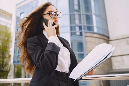Businesswoman standing outdoors in city office building backgroundの写真素材