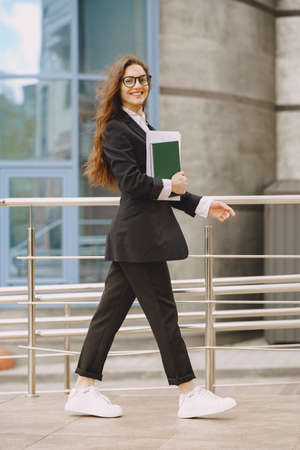 Businesswoman standing outdoors in city office building backgroundの写真素材