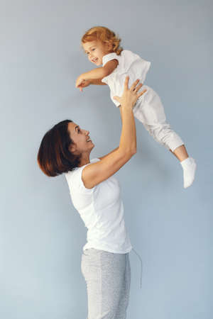 Mother and little daughter have fun on a blue backgroundの写真素材