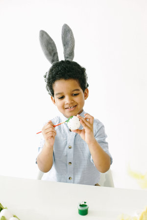 African boy is preparing for Easter at table