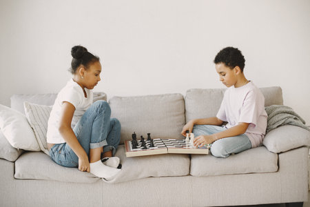 Boy and girl playing chess on the couch