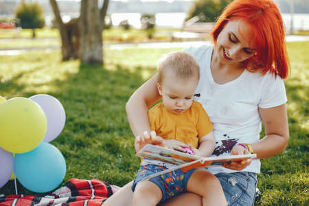 Mother with son playing in a summer parkの写真素材