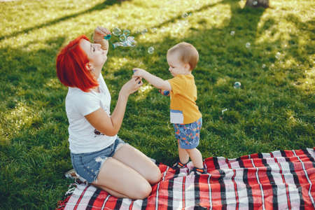Mother with son playing in a summer parkの写真素材