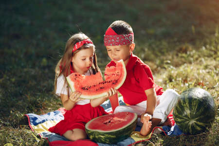 Cute little children with watermelons in a parkの写真素材