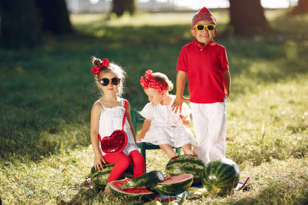 Cute little children with watermelons in a parkの写真素材