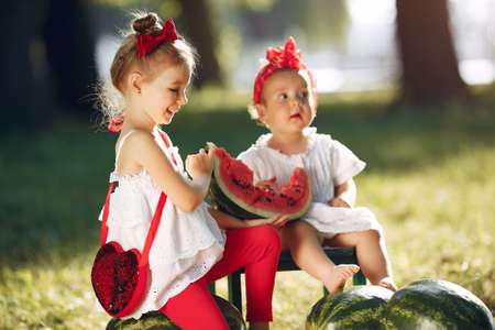 Cute little children with watermelons in a parkの写真素材