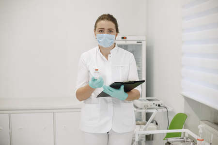 Woman hold corona vaccine in her handsの写真素材