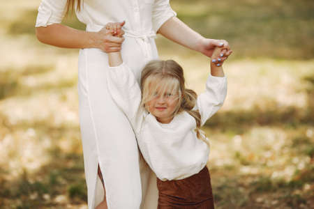 Mother with little daughter playing in a summer parkの写真素材