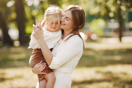 Mother with little daughter playing in a summer parkの写真素材