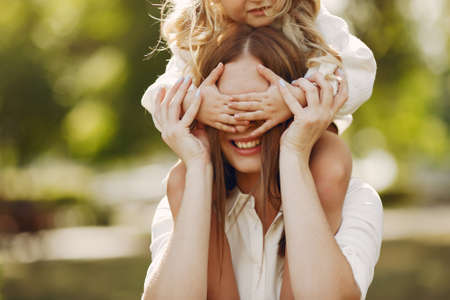 Mother with little daughter playing in a summer parkの写真素材