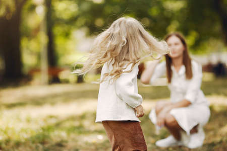 Mother with little daughter playing in a summer parkの写真素材