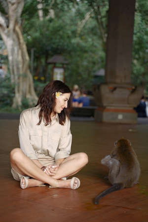 Woman on vacation playing with a monkeyの写真素材