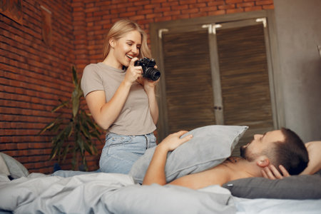 Couple sitting on a bed in a roomの写真素材