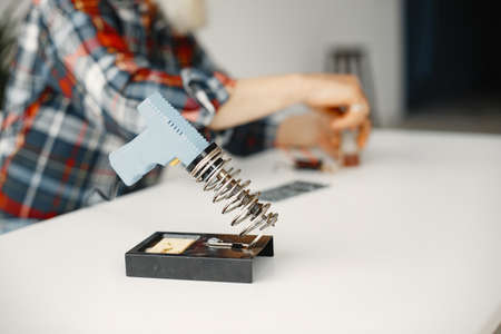 Male tech repairs electronic equipment at homeの写真素材