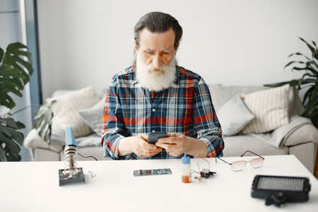 Senior technician check phone after repairmentの写真素材