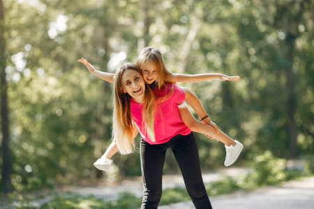 Mother with daughter playing in a summer parkの写真素材