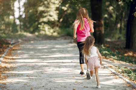 Mother with daughter playing in a summer park