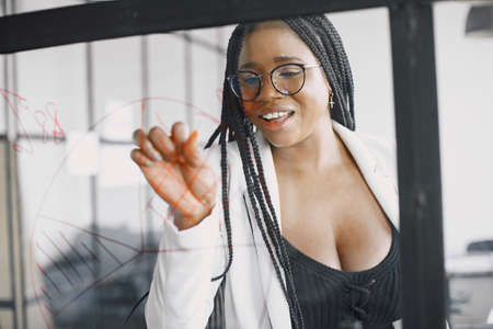 Businesswoman talking and writing on transparent boardの写真素材