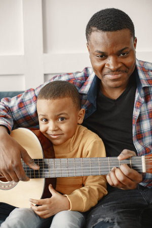 Father teaches his son to play guitar
