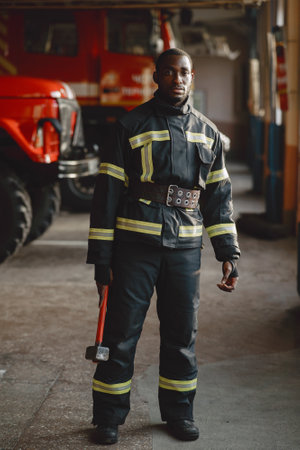 Portrait of a firefighter standing in front of a fire engineの写真素材