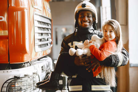 Portrait of a firefighter standing in front of a fire engineの写真素材