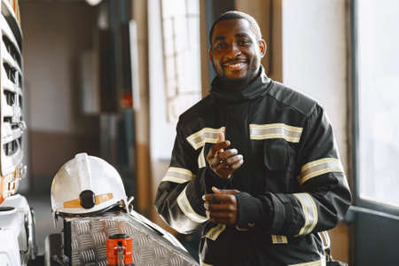 Portrait of a firefighter standing in front of a fire engineの写真素材
