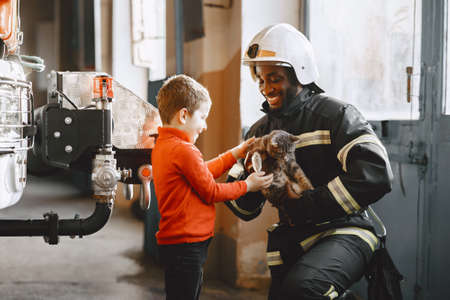 Portrait of a firefighter standing in front of a fire engineの写真素材