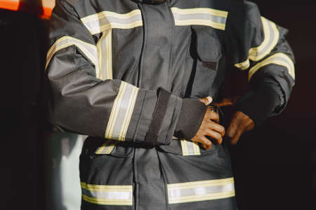 Portrait of a firefighter standing in front of a fire engineの写真素材