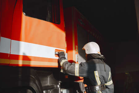 Portrait of a firefighter standing in front of a fire engineの写真素材