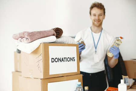 Volunteer guy packs boxes with a humanitarian helpの写真素材