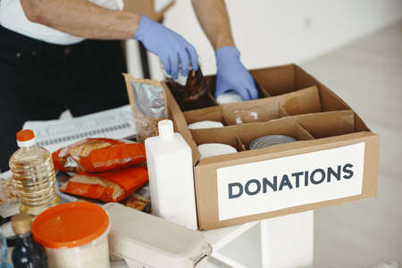 Volunteer guy packs boxes with a humanitarian helpの写真素材
