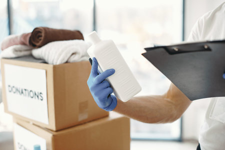 Volunteer guy packs boxes with a humanitarian helpの写真素材