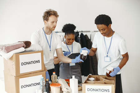 Two boys and a girl volunteers pack humanitarian aidの写真素材