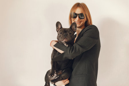 Elegant woman in a black suit with black bulldogの写真素材
