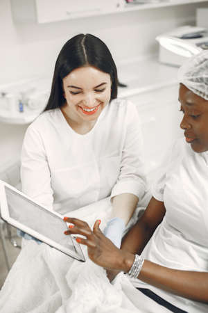 Beautician consults an african girl in officeの写真素材