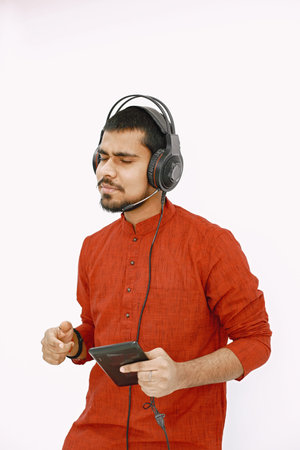 Indian man in headphones and tablet listening to music
