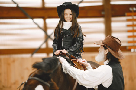 A little child riding a horse with an instructor
