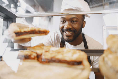 Agrican american baker selling buns in cafeteriaの写真素材