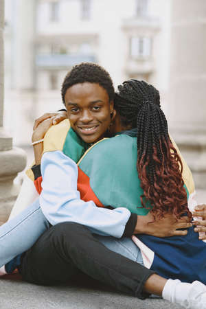 Ethnic couple sitting in city streetの写真素材